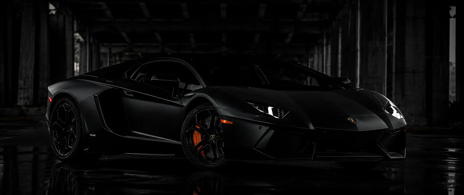 Matte black Lamborghini Aventador in a private garage